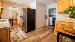 Eine moderne Küche mit Holzausstattung, einem Edelstahlkühlschrank und Holzboden.