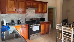 Una cocina con armarios de madera, estufa, microondas y lavaplatos.