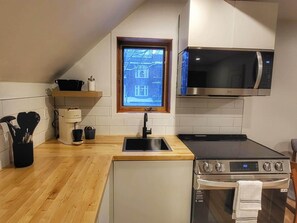 Una cocina moderna con microondas, horno y lavaplatos integrados.