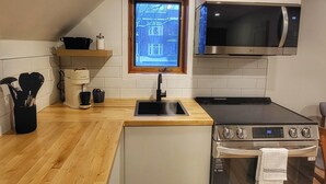 A compact kitchen with a microwave, stove, and sink. - Brilliant 1-bedroom apartment with AC in charming Québec (Québec)
