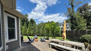 A patio with a wooden table and chairs, a small round table, and an umbrella. - Adjacent to UVA Grounds, WALKABLE to Scott Stadium, Corner, Downtown (Charlottesville)