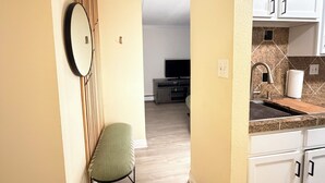A modern kitchen with white cabinets, a granite countertop, and a built-in oven. - Penthouse condo in central Cheesman Park! (Denver)