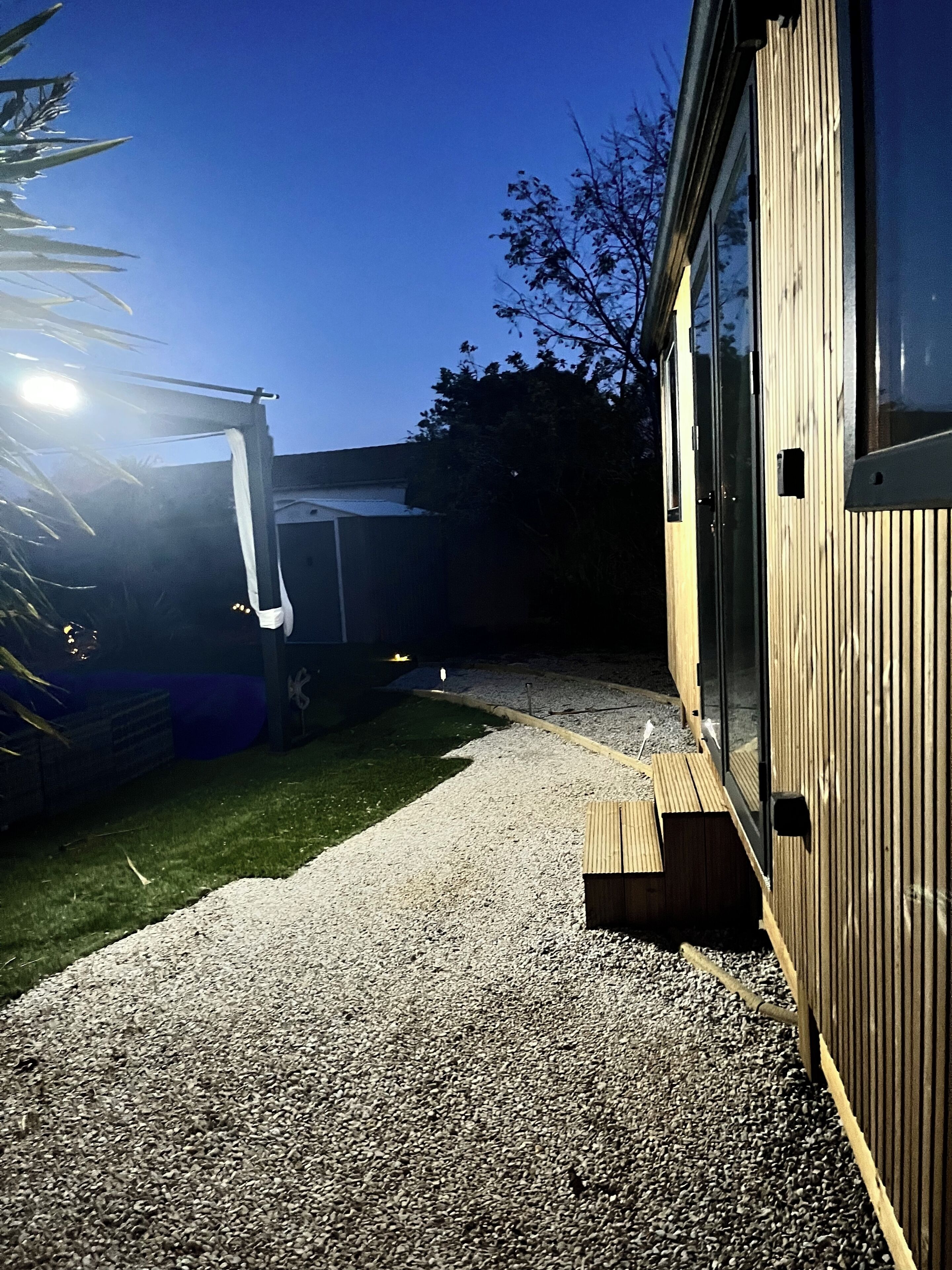 A wooden building with a gravel pathway leading to a door.