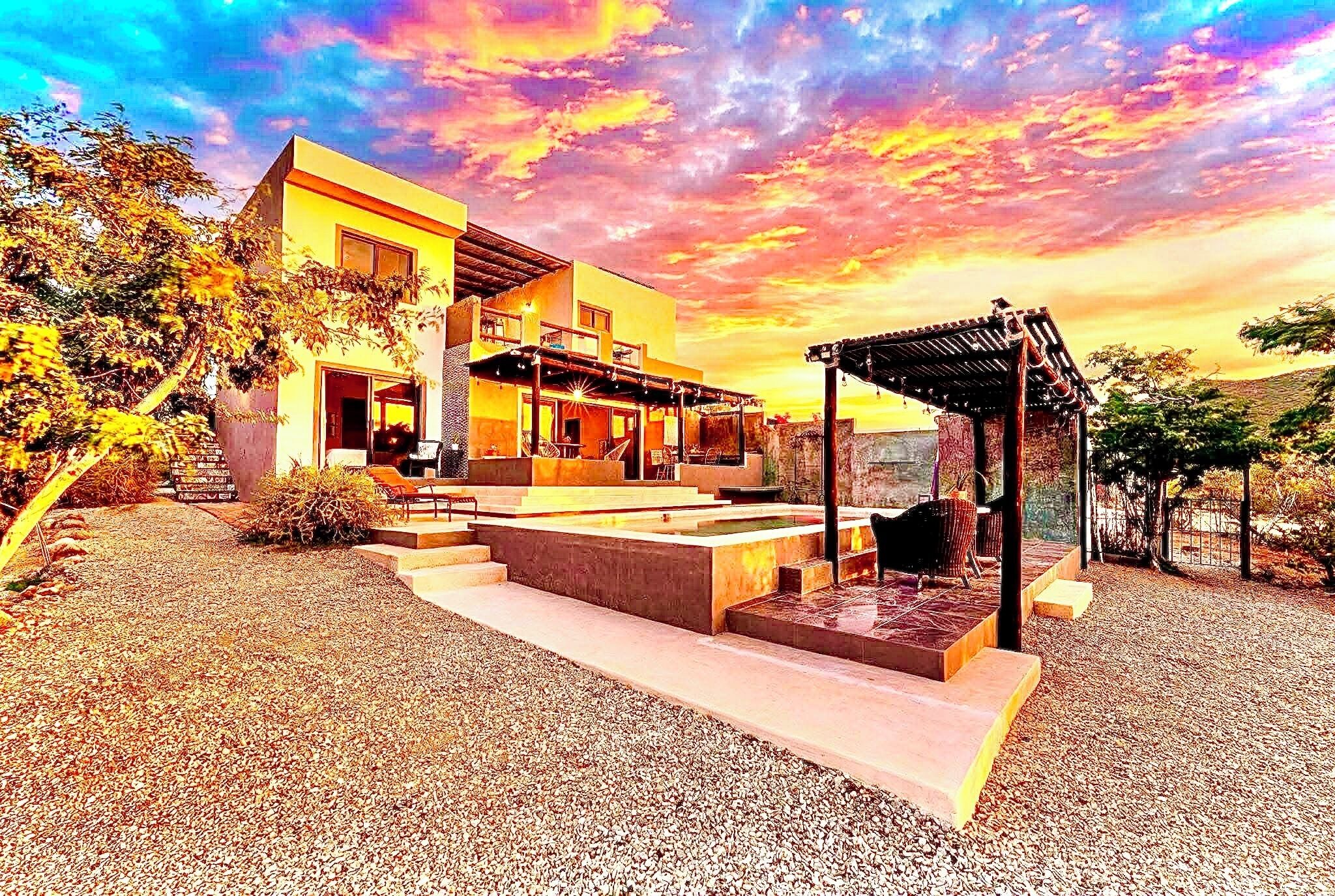 Une maison moderne dotée d’un patio, d’une pergola et offrant une vue sur le ciel.
