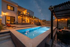 A modern outdoor pool area with a clear blue pool, a covered seating area, and string lights. - Amazing Sea & Mountains Views
3 bed 4n half bathroom
Private 7m by 3mChukum pool (San Jose del cabo)