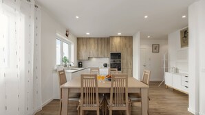 Eine moderne Küche mit Holzausstattung, einem Esstisch mit Stühlen und einer weißen Arbeitsplatte.