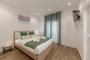Camera da letto moderna con un letto in legno, cuscini verdi e bianchi, una coperta verde e una lampada da terra.