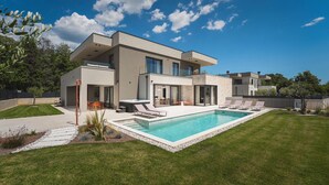 A modern two-story house with a swimming pool, outdoor seating, and a well-maintained lawn. - Awesome home in Funtana (Funtana)
