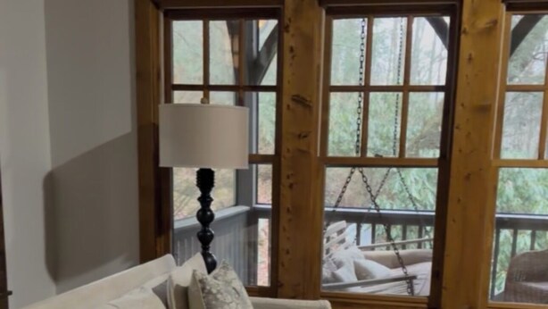 A living room with a beige sofa, a wooden coffee table, and a large window with wooden frames. - Cashiers, Trillium Lake Glenville Mountain Home 2 bedroom plus kids bunk room (Cashiers)