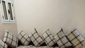 Una sala de estar con un sofá modular, una mesa de centro de vidrio y una alfombra estampada.