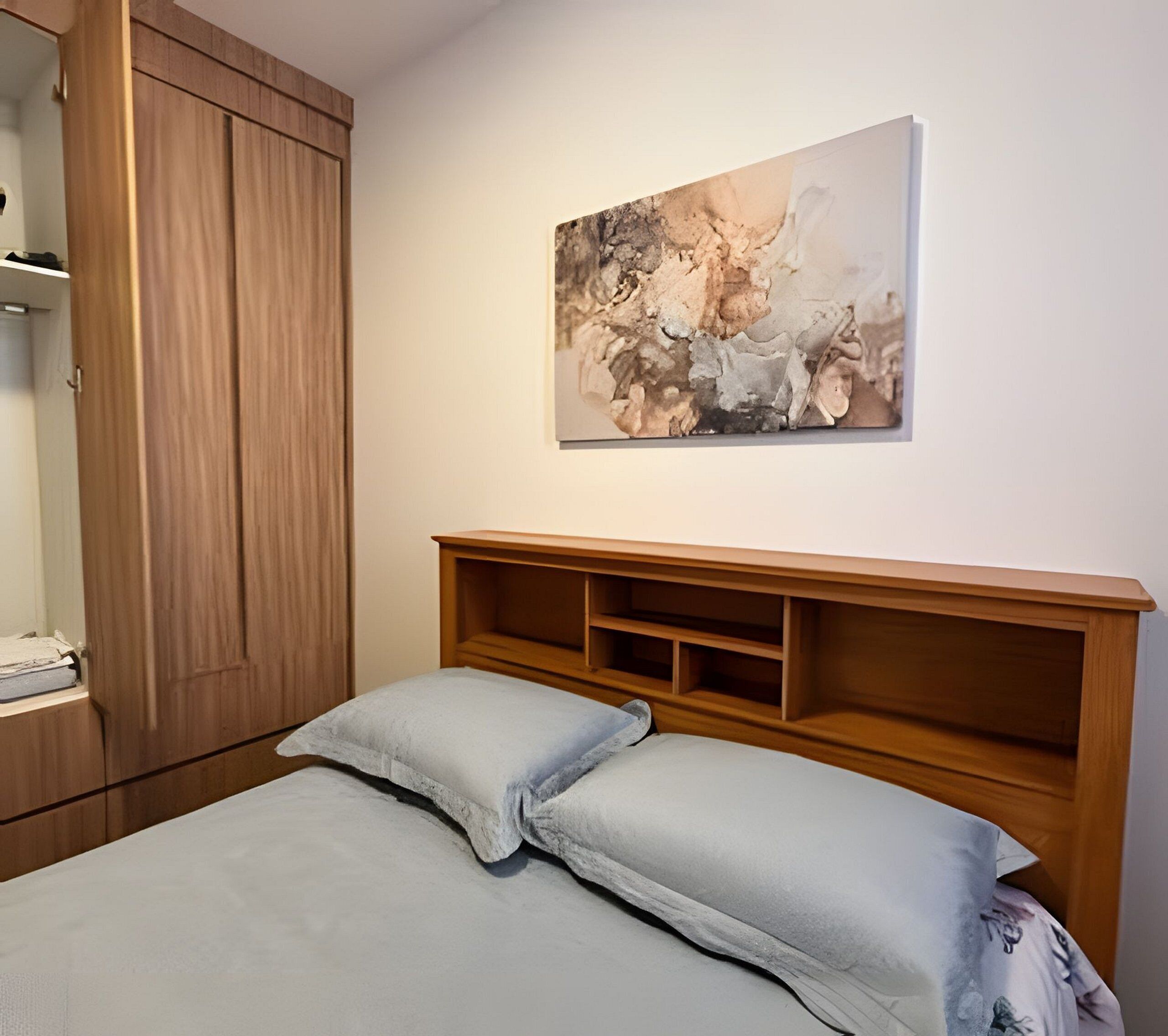 Un dormitorio con cama, cabecero de madera y un cuadro en la pared.