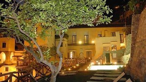 A building with a courtyard, a tree, and a bridge.
