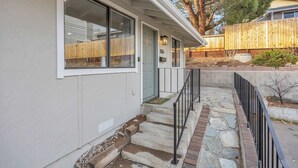 A house with a front porch, stone steps, and a wooden fence. - Tranquil Oasis Duplex/5Baths/Sleeps 15 (Reno)