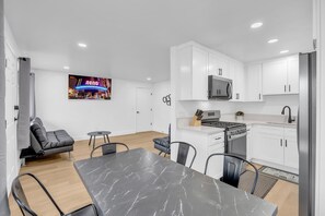 A modern kitchen with white cabinets, a built-in microwave, and a stainless steel refrigerator. - Tranquil Oasis Duplex/5Baths/Sleeps 15 (Reno)