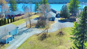 A residential area with houses, a driveway, and a lake in the background. - Luxury Lake House - Hot Tub - Fire Pit - BBQ -Dock (Hasting)