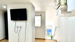 Ein modernes Wohnzimmer mit einem an einer weißen Wand befestigten Flachbildfernseher und einer Steckdose.