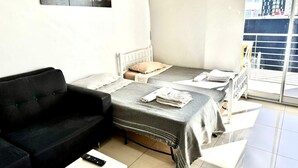 Ein Hotelzimmer mit einem Bett, einer schwarzen Couch, einem kleinen Tisch und einem Gemälde eines Löwen.