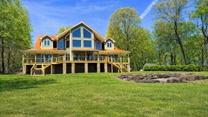 A large, multi-story house with a prominent front porch, multiple windows, and a stone foundation. - Panoramic Views at Paul’s Point (Altamont)