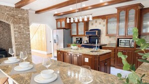 A modern kitchen with granite countertops, wooden cabinets, and a central island. - Panoramic Views at Paul’s Point (Altamont)