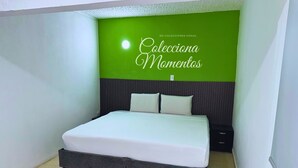 Ein Schlafzimmer mit einem Bett, einem Kopfteil und einer grünen Wand mit Text.