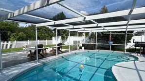 Ein überdachter Außenpool, über dem ein klarer, blauer Himmel zu sehen ist.