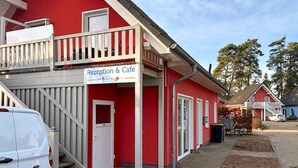 Un bâtiment rouge avec une enseigne indiquant « Réception et café ».