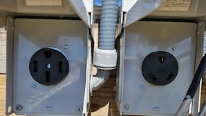 Deux panneaux électriques avec des prises visibles et un conduit.