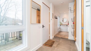 A modern hallway with a wooden floor, white walls, and large windows. - Superb views and literally 2 min walk to resort ! (Mont-Tremblant)