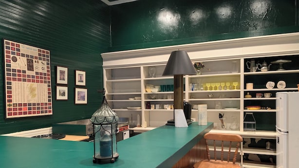 A kitchen with a teal countertop, a black lamp, and wooden chairs. - Unique fun 2-bedroom apt with large great room kitchen combo and cool AC (Ailey)