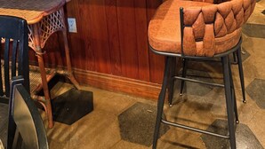 A bar area with a green countertop, wicker chairs, and shelves with various items. - Unique fun 2-bedroom apt with large great room kitchen combo and cool AC (Ailey)