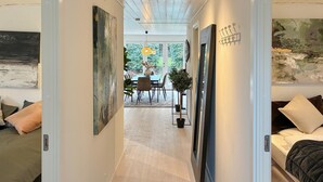 A hallway leading to a dining area with a table and chairs, a potted plant, and artwork on the walls. - Beautiful home in Dronningmølle with WiFi (Dronningmølle)