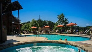 Un área de piscina con varios jacuzzis, sombrillas y sillones de descanso.