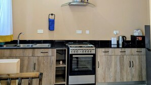 Une cuisine équipée d’une cuisinière, d’un four et d’une hotte en acier inoxydable.