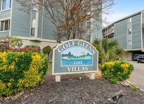 A sign for 'Golf Glen Villas' with a golf course illustration, located in front of a building with a blue exterior. - North Myrtle Beach Golf Glenn Villa (North Myrtle Beach)
