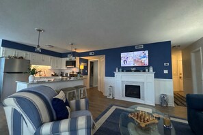 Smart TV, chimenea, libros y monitor de computadora 
