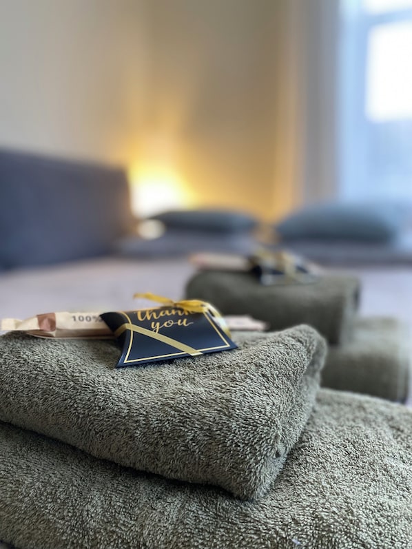 A neatly arranged set of grey pillows with a thank you card on top.