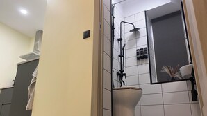 Un baño moderno con inodoro, ducha y lavabo.