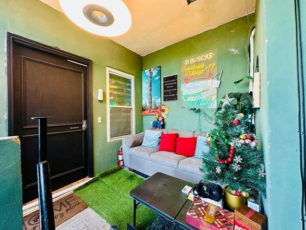 Una sala de estar acogedora con un sofá gris, una mesita de centro y un árbol de Navidad.