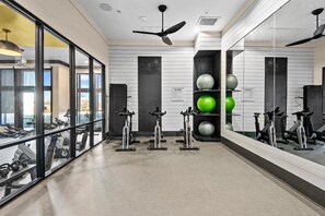 A gym with exercise bikes, a yoga mat, and exercise balls.