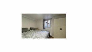 Une chambre à coucher avec un lit, une fenêtre et une armoire.