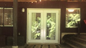 Un bâtiment en bois doté d’une porte à double vitrage, d’un petit porche et d’un escalier menant à l’entrée.