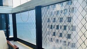 Un balcón con vistas a un paisaje urbano, que incluye una silla y una mesa.