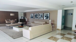 Una sala de estar moderna con sofá, mesa de centro y comedor con sillas y mesa.