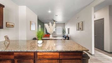 A kitchen with a granite countertop, wooden cabinets, and a ceiling fan.