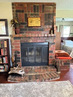 A fireplace with a stone surround, a framed certificate above it, and a violin leaning against the wall. - Private Ranch Retreat with Panoramic Views of the Wichita Mountains (Roosevelt)