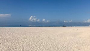 Een strand met een heldere lucht en een verre horizon.