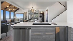 A modern kitchen with a central island, built-in appliances, and a dining area with a view. - Best View in Beech Mountain ski in, ski out, sauna (Beech Mountain)