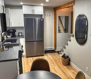 A compact kitchen with a stainless steel refrigerator, a coffee maker, and a toaster. - Adorable 1-bedroom apartment with AC in charming Québec (Québec)