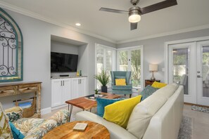 A living room with a sofa, a coffee table, a TV, and a ceiling fan. - Cozy 1BR King suite in Palmetto Dunes, Hilton Head Island, perfect for couples! (Hilton Head Island)