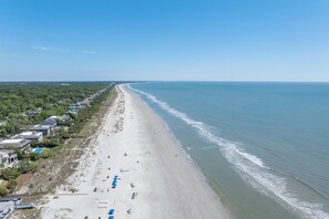 An aerial view of a beach with a long stretch of sand, a few buildings, and a clear sky. - Cozy 1BR King suite in Palmetto Dunes, Hilton Head Island, perfect for couples! (Hilton Head Island)